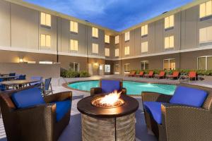 un patio del hotel con una hoguera y una piscina en Holiday Inn Express Hotel & Suites Auburn - University Area, an IHG Hotel, en Auburn