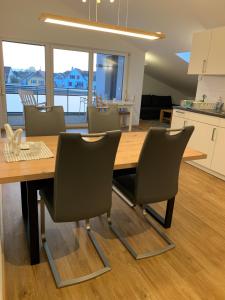 a kitchen and dining room with a wooden table and chairs at Ferienwohnung Baselblick, Eimeldingen in Eimeldingen