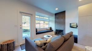 a living room with a couch and a fireplace at Lakefront Oasis by Harmony Whistler in Whistler