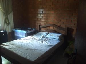 a bed in a room with a brick wall at Gravatá Country House in Gravatá +39 photos