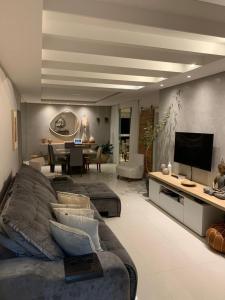 sala de estar con sofá y TV en COBERTURA com belíssima vista para o mar e jacuzzi, en Itapema