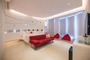 a living room with a red couch and a bed at 澎湖遛一遛旅店 in Magong