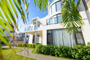 a white house with a palm tree in front of it at 澎湖遛一遛旅店 in Magong +9 photos