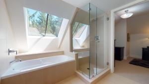 a bathroom with a bath tub and a window at Stylish Home with Mountain Views by Harmony Whistler in Whistler +27 photos