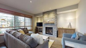 a living room with a couch and a fireplace at PRIVATE Hot Tub In Prestigious Nicklaus North by Harmony Whistler in Whistler