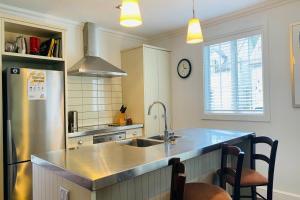 cocina con fregadero y nevera en Settler's Cottage - Russell Cottages Collection, en Russell