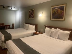 Postel nebo postele na pokoji v ubytování Hotel and Suites Les Laurentides