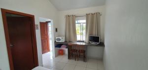 a room with a desk with a computer and a window at Pousada Talismã in Florianópolis