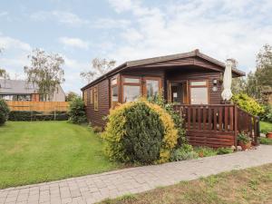 a tiny house with a porch and a yard at 4 Country View Park in Faversham