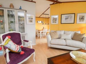 ein Wohnzimmer mit einem Sofa und einem Stuhl in der Unterkunft 4 Country View Park in Faversham