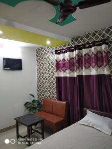 瓦拉納西的住宿－New Hotel Yatri Niwas，一间卧室配有一张床、一张沙发和一个天花板