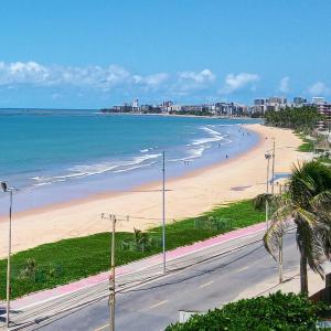 a view of a beach with people walking on it at Flat em Hotel de Luxo beira mar da grife Ritz suítes com vista ampla para todo o mar da cruz das almas, jatiúca e ponta verde, com toda estrutura de um hotel lindo e arrojado, academia, piscina e muito mais, venha viver essa experiência incrível! in Maceió