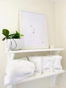 uma prateleira branca com toalhas brancas e uma fotografia em Farm Cottage close to Dubbo em Dubbo
