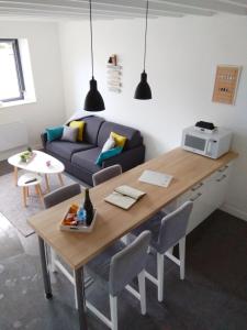 een woonkamer met een tafel en een bank bij Maison Cosy entre CAP FREHEL et SAINT MALO 1km PLAGE 5min GR34 Wifi Jardin Vélos "CASA OHANA" in Saint-Cast-le-Guildo