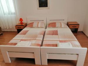 two beds in a bedroom with two night stands at Oaza duplex in Dubrovnik