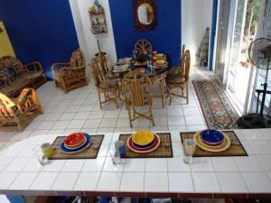Puerto San José, Casa 33 Condominio Alta Mar في Chulamar: غرفة معيشة مع طاولة عليها لوحات