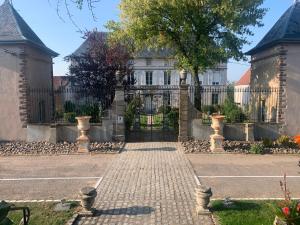 エピナルにあるLe Château de Faillouxの門と煉瓦の私道のある家