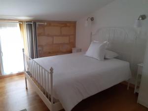 um quarto com uma cama branca e uma janela em Domaine du chauvet em Sainte-Eulalie