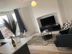 een woonkamer met een flatscreen-tv en een bank bij Seascape Seaview Apartment hot tub hire subject to availability in Scarborough +19 foto's