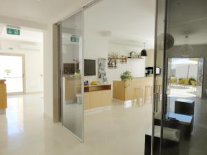 a kitchen and living room with a glass wall at Hotel Sole in Lampedusa