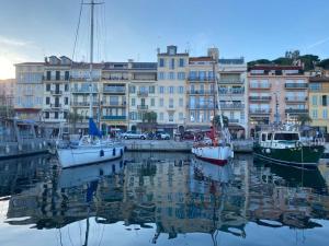 un groupe de bateaux amarrés dans un port avec des bâtiments dans l'établissement Cannes Old Port, Seafront & Seaview , fast wifi, best AC, à Cannes