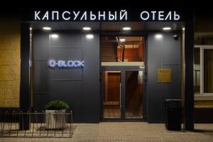 een gebouw met een blauw bord aan de zijkant bij Q-Block Сapsule Hotel in Moskou