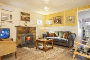 uma sala de estar com um sofá e uma lareira em Bonnie Brae Cottage em Hepburn Springs