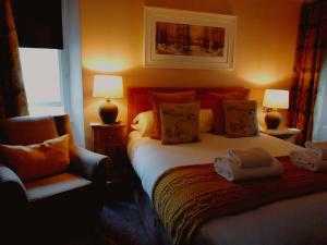 - une chambre avec un lit, deux lampes et une chaise dans l'établissement Oakfold House, à Bowness-on-Windermere