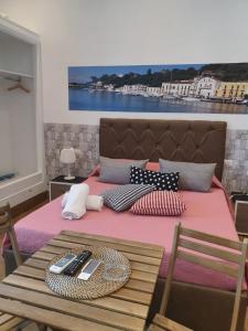 a bed with a pink blanket and a table at Casa Vacanze Riva Destra in Ischia