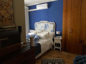um quarto com uma cama com uma parede azul em Perhethian em Cidade do Cabo