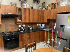 uma cozinha com armários de madeira e uma mesa com velas em Perhethian em Cidade do Cabo