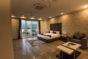 HOLYWATER by Ganga Kinare في ريشيكيش: غرفة نوم بسرير واريكة وطاولة
