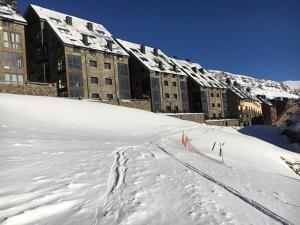 una pista da sci di fronte a un edificio nella neve di Lux Isard "Acceso directo a pistas" a Pas de la Casa