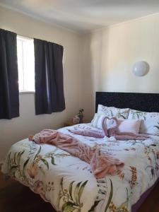 a bedroom with a bed with pink blankets on it at Park Beach Cabins in Coffs Harbour