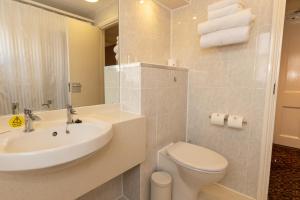 a white bathroom with a sink and a toilet at The Darlington Hyde Park in London