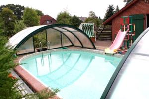 a swimming pool with a slide and a playground at Ferienhof Stadtländer in Mardorf am Steinhuder Meer in Neustadt am Rübenberge