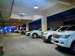 Submukda Phoomplace Hotel في موكداهان: مجموعة من السيارات تقف في موقف للسيارات