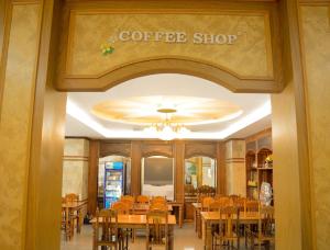 un restaurante con mesas y sillas y un letrero de cafetería en Submukda Phoomplace Hotel en Mukdahan