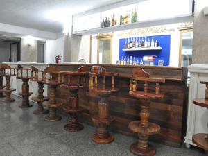 a row of wooden bar stools in a restaurant at Highfive Hotel Pattaya in Pattaya Central