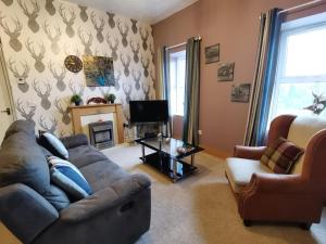 a living room with a couch and a tv at Gwynedd House Flat 2 in Pentraeth