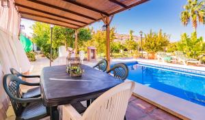 - une table et des chaises sur une terrasse avec piscine dans l'établissement Cubo's Casa Rural Huertecilla Macias, à Alhaurín el Grande