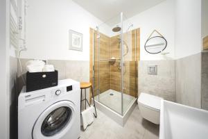 a bathroom with a washing machine and a shower at Apartament Lubię Morze in Jantar