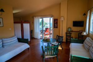 a living room with a couch and a table with chairs at The Yellow Houses in Agios Nikolaos