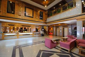 a lobby with pink chairs and a bar at Betong Merlin Hotel in Betong