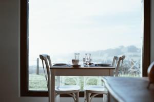 a table and chairs with a table and a window at Finca El Palomar de Luanco in Luanco