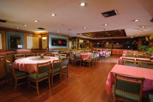 a restaurant with tables and chairs with pink table cloth at Betong Merlin Hotel in Betong