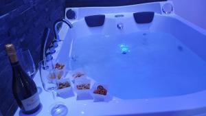 a bath tub with a bottle of wine and chocolates at Messina41 Hotel in Messina