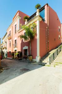 een gebouw met palmbomen aan de zijkant bij Relais Briuccia e Ristorante Capitolo Primo in Montallegro