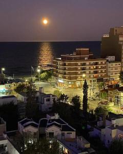 a view of a city at night with the ocean at Sueños del Golfo in Puerto Madryn