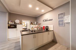 a kitchen with white cabinets and a counter top at Ferienwohnungen am Wintergarten in Gera